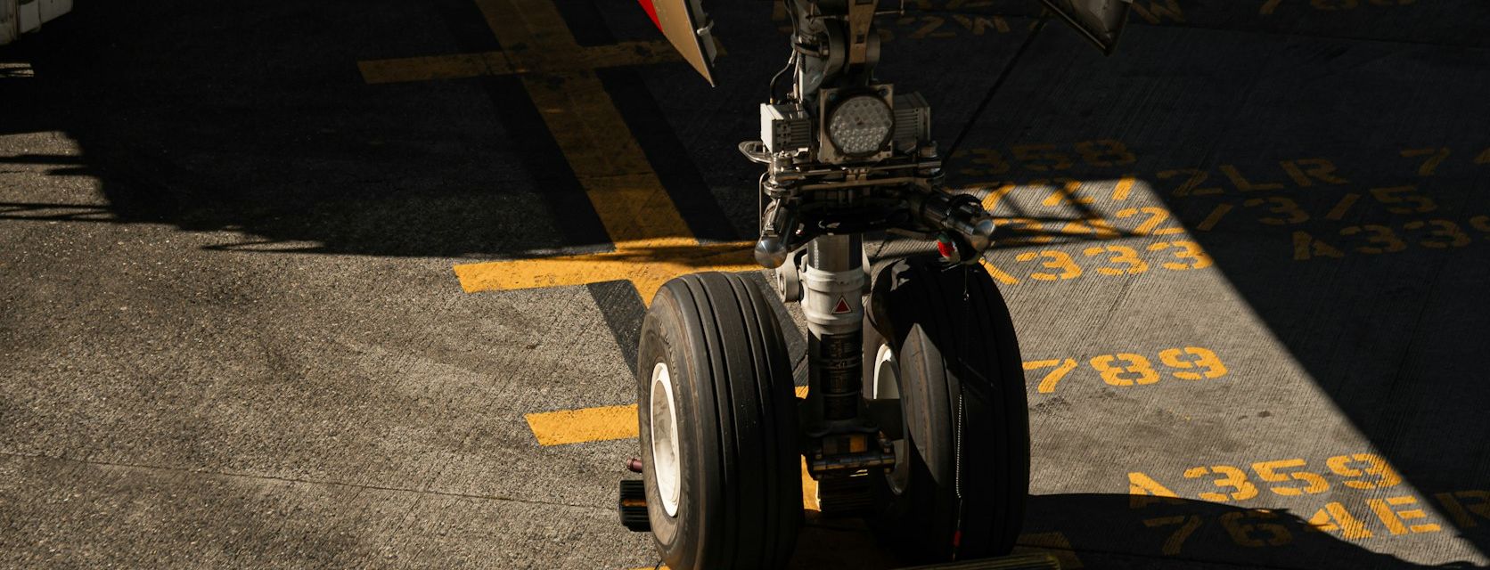 Aircraft nose landing gear and tires on an airport apron